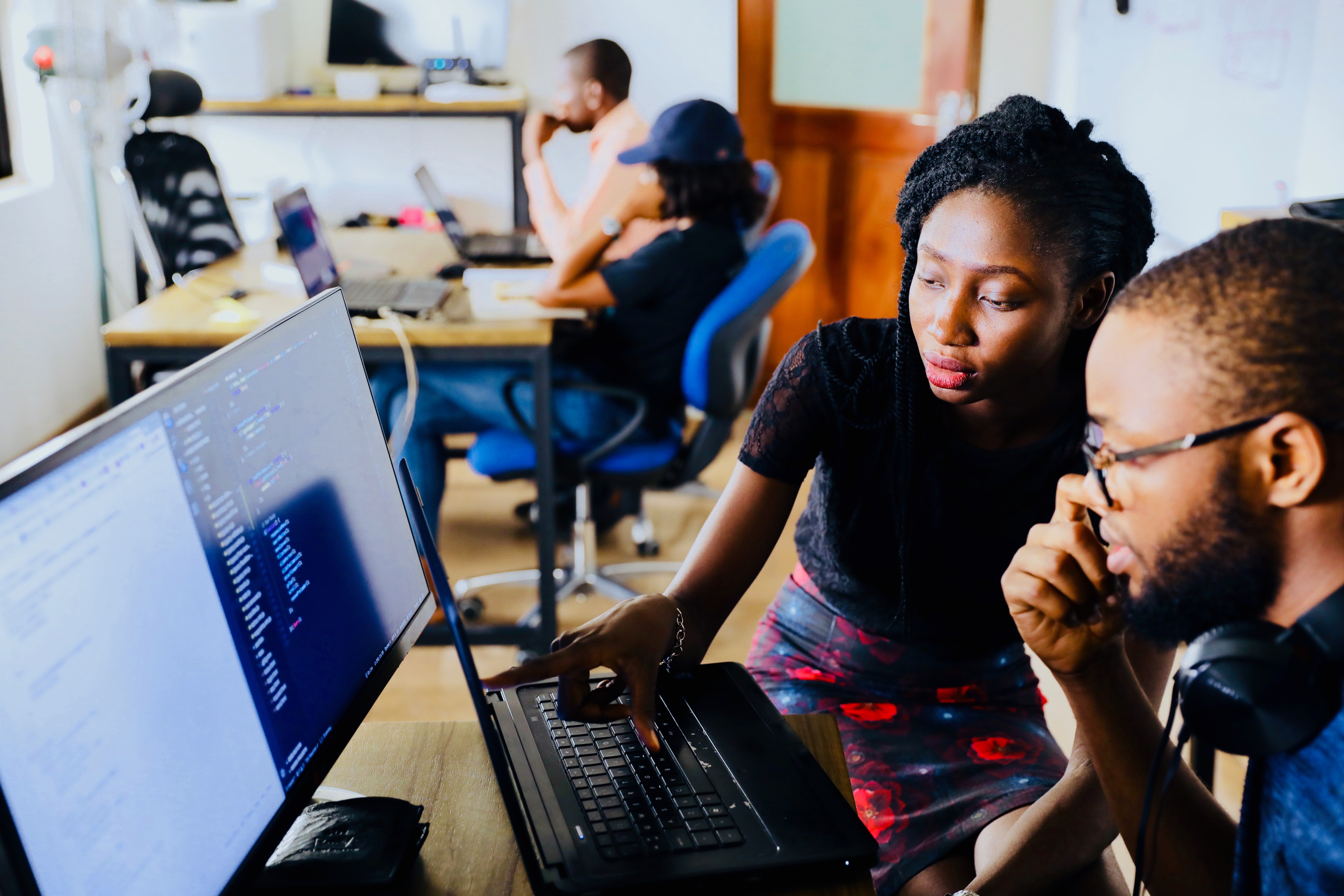 Deux entrepreneurs noirs qui regardent un écran d'ordinateur avec du code.