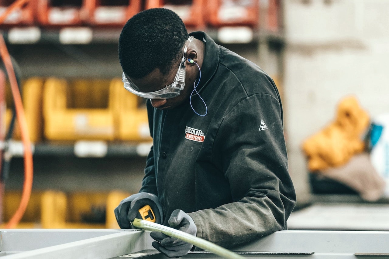 Black skilled trades worker using measuring tape